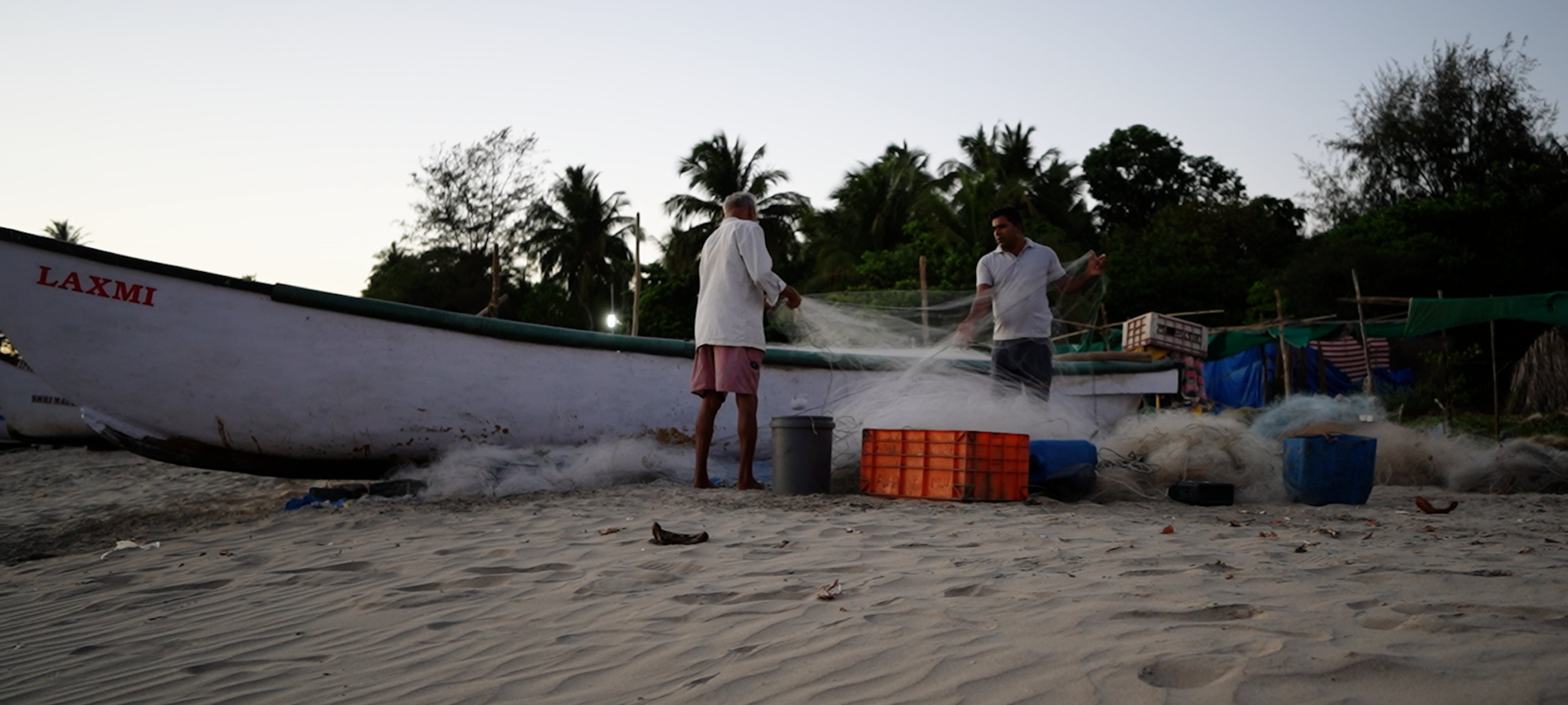 Cinematic shot of fishermen working on a beach.